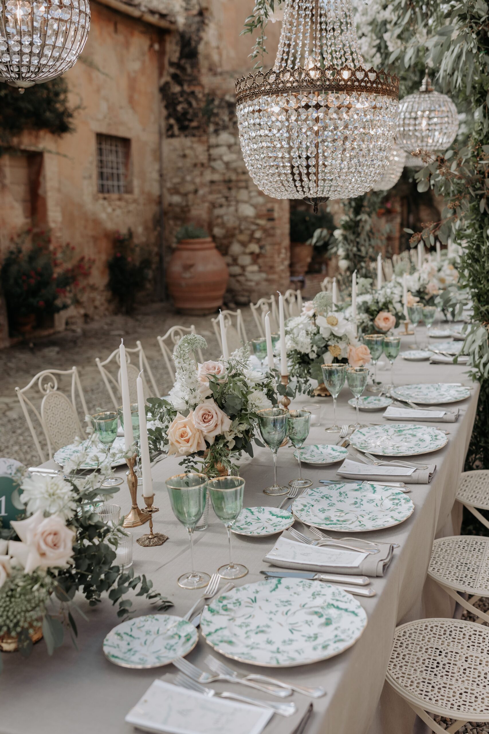 Soft pink and green setup on Imperial tables with candles and crystal chandeliers